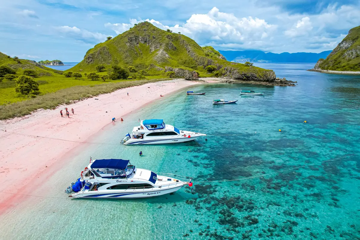 Boats anchored off the pink sand beach at Komodo Island, Indonesia