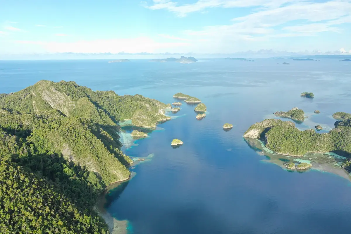 Aerial view of the green islands and turquoise channels of Raja Ampat, West Papua