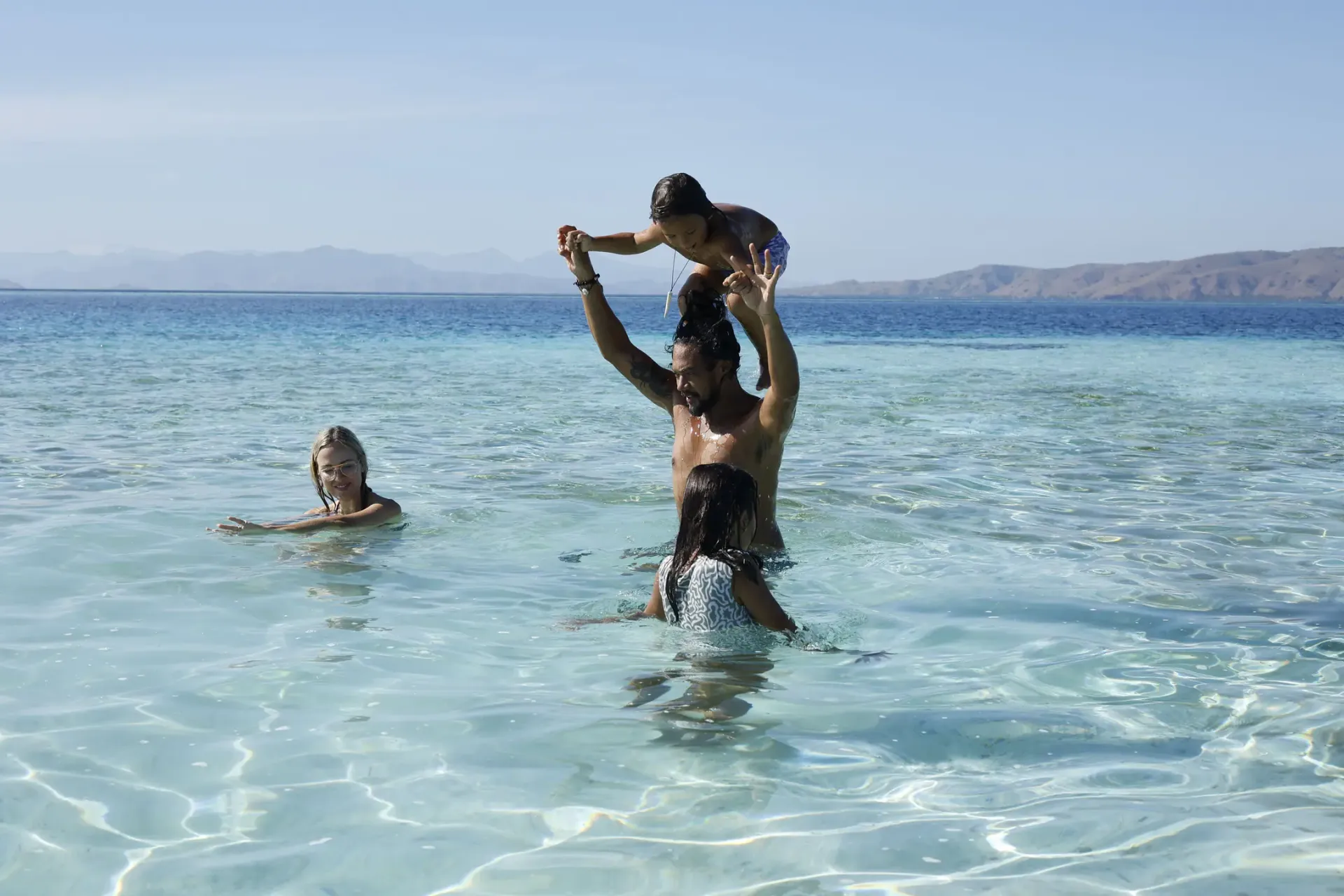 Family playing crystal clear water Komodo Islands luxury yacht charter