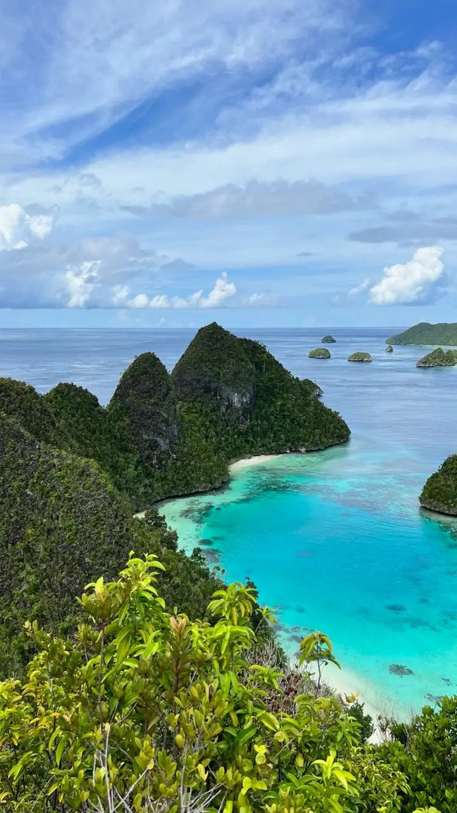 Turquoise bay framed by green karst islands in Raja Ampat, Indonesia